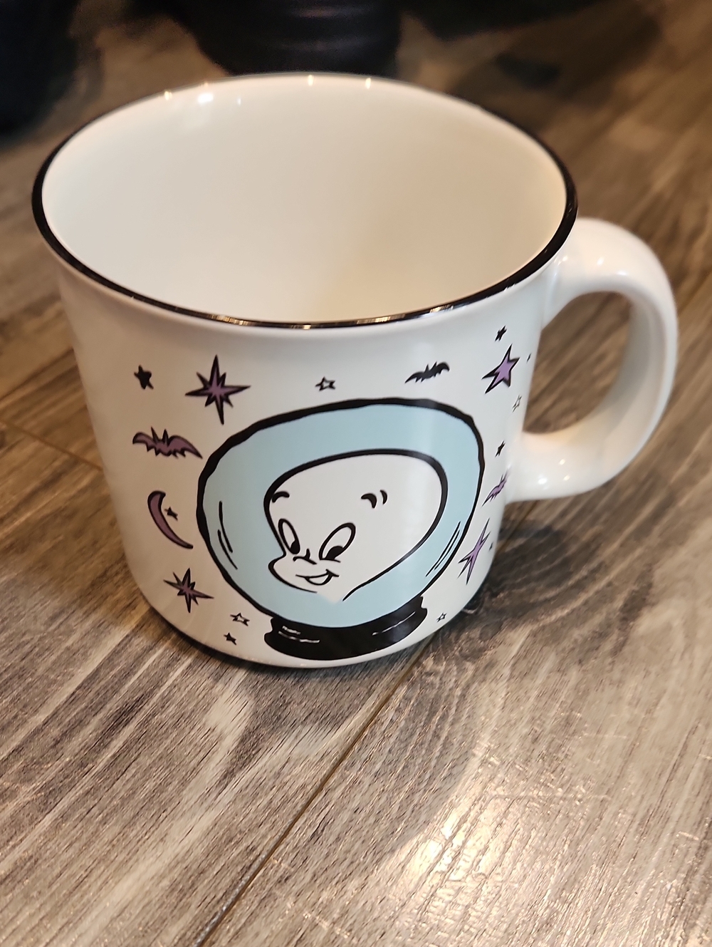 White Ceramic Mug with Light Blue Ghost Illustration and Black Rim